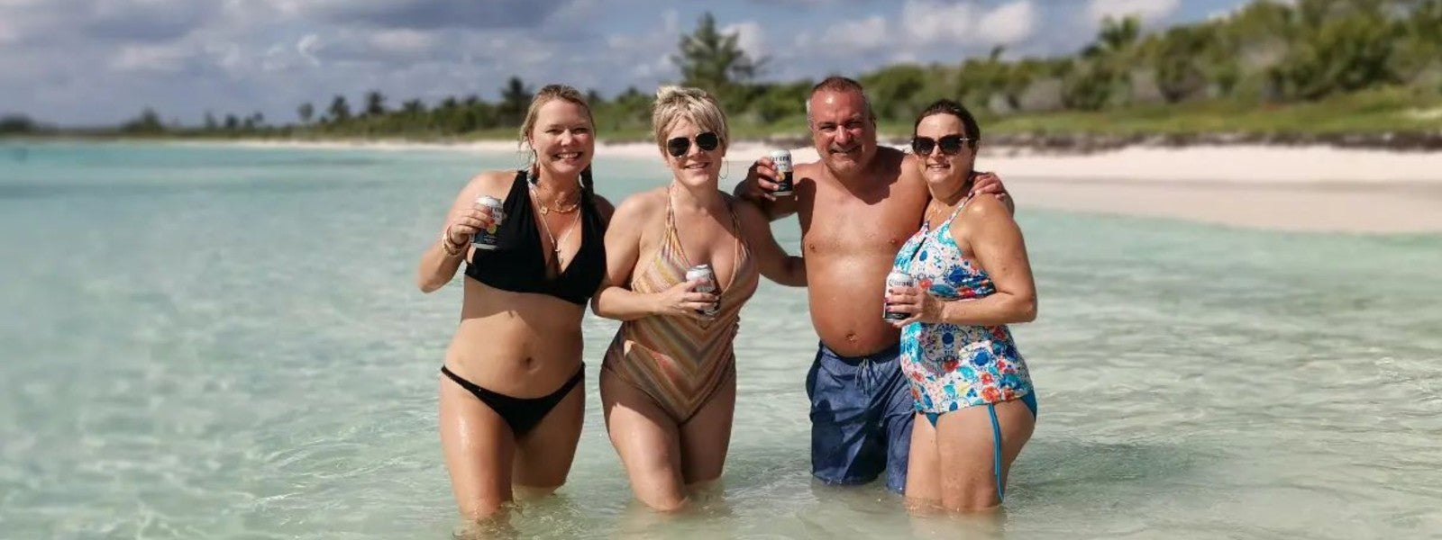Happy clients enjoying a private beach stop with Beyond the Experience yacht charter in the Riviera Maya, perfect for relaxation and fun